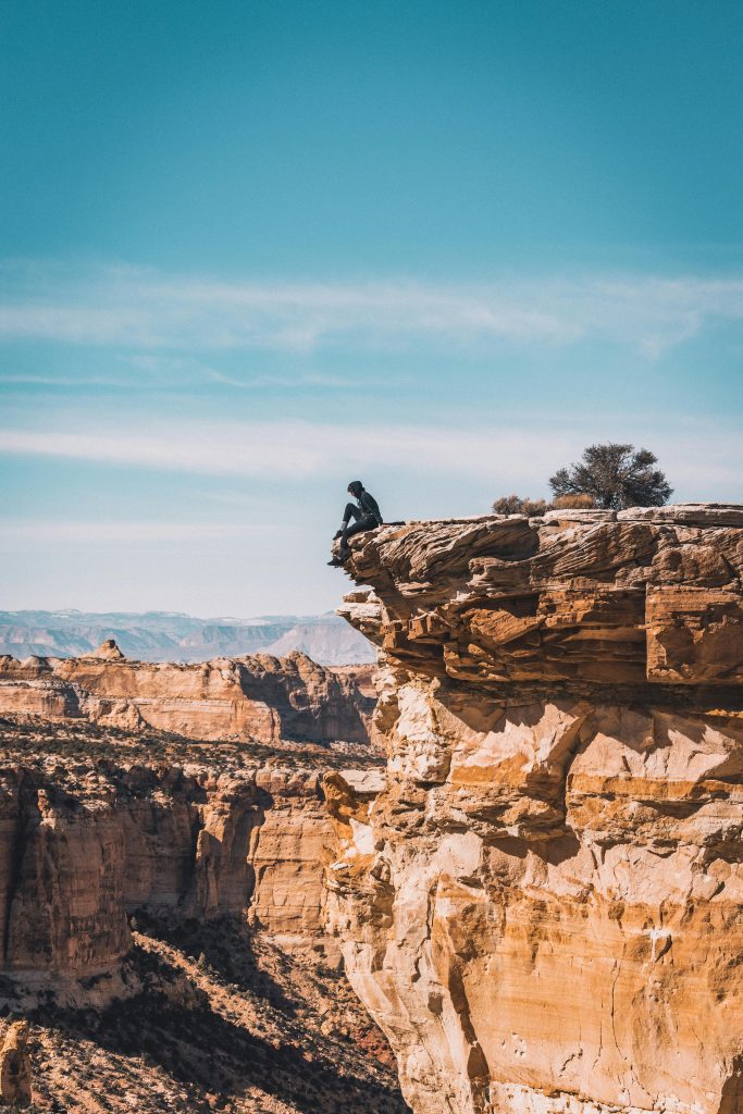 Hiker perched on a stunning canyon cliff, capturing the essence of adventure and nature.